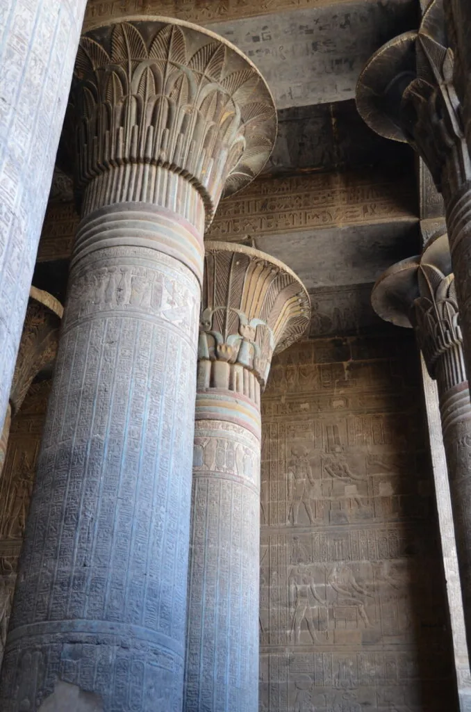 Ancient Egyptian temple columns with carved papyrus capitals and hieroglyphic inscriptions on walls