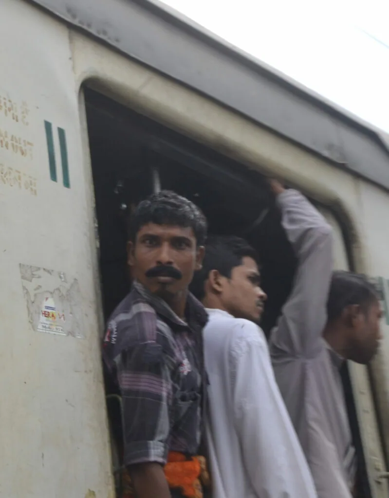 Multiple people crowded in a train doorway or compartment opening