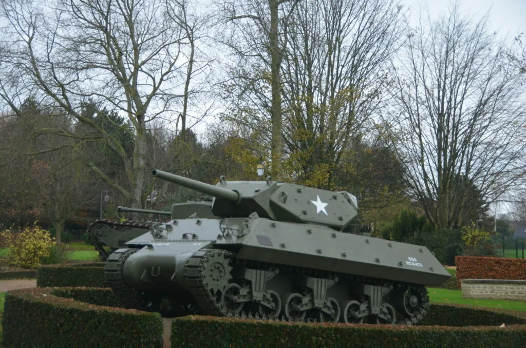 M4 Sherman tank with white star marking displayed in landscaped park setting with bare trees