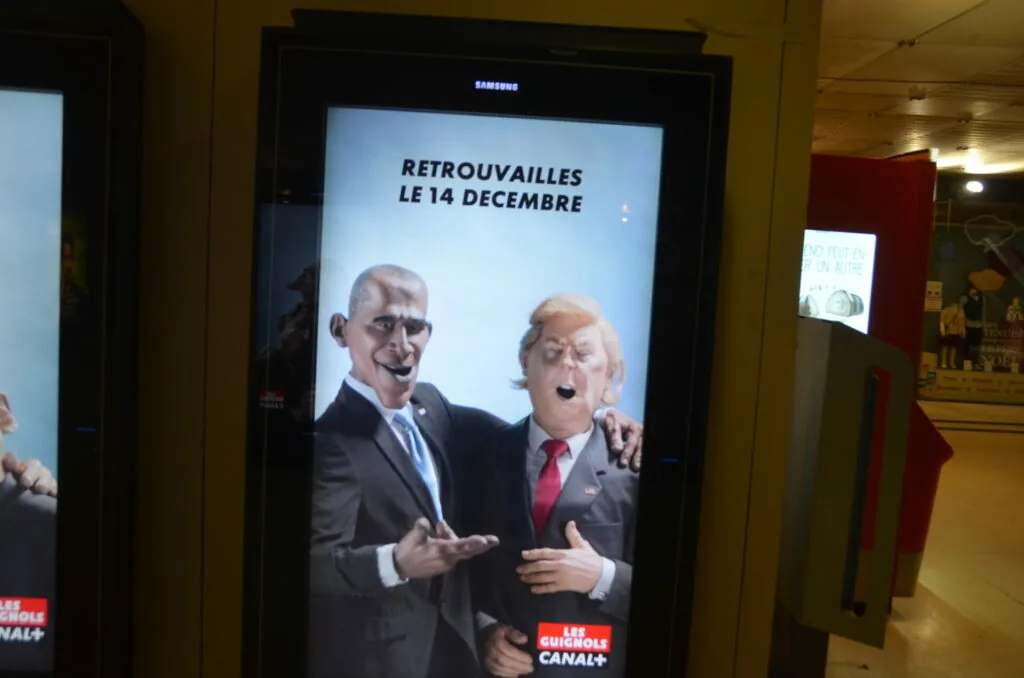 Digital display advertising French television program with two animated men in suits, text reading 'RETROUVAILLES LE 14 DECEMBRE'