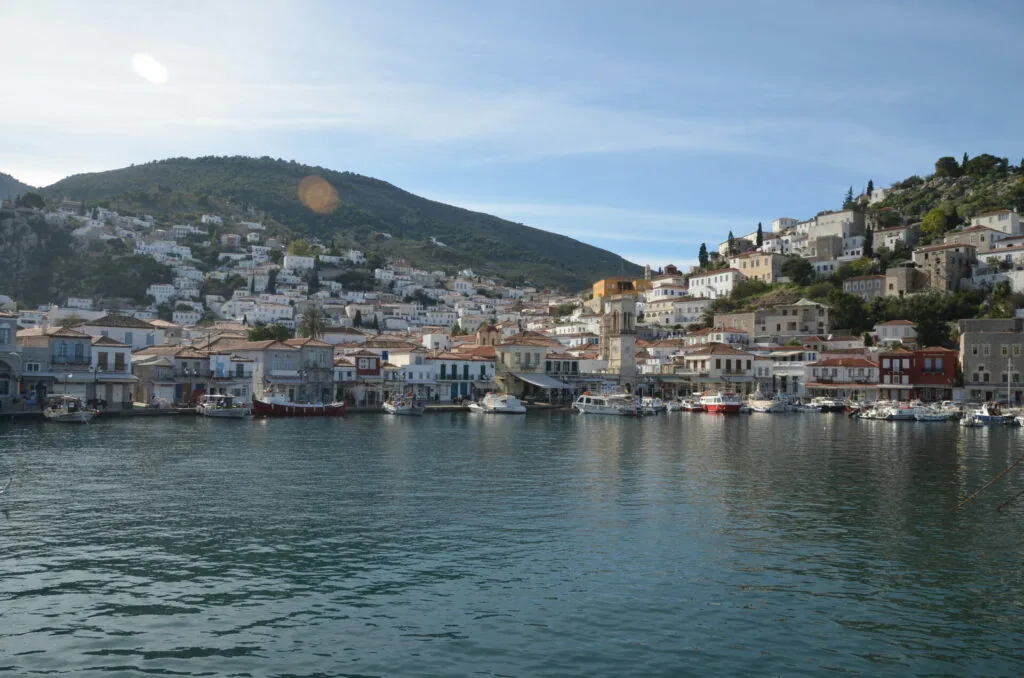 Waterfront town with colorful buildings and boats nestled along a hillside overlooking calm turquoise water