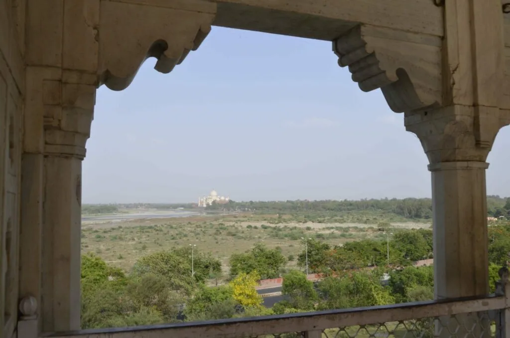 Stone archway framing distant monument and landscape with river and green vegetation