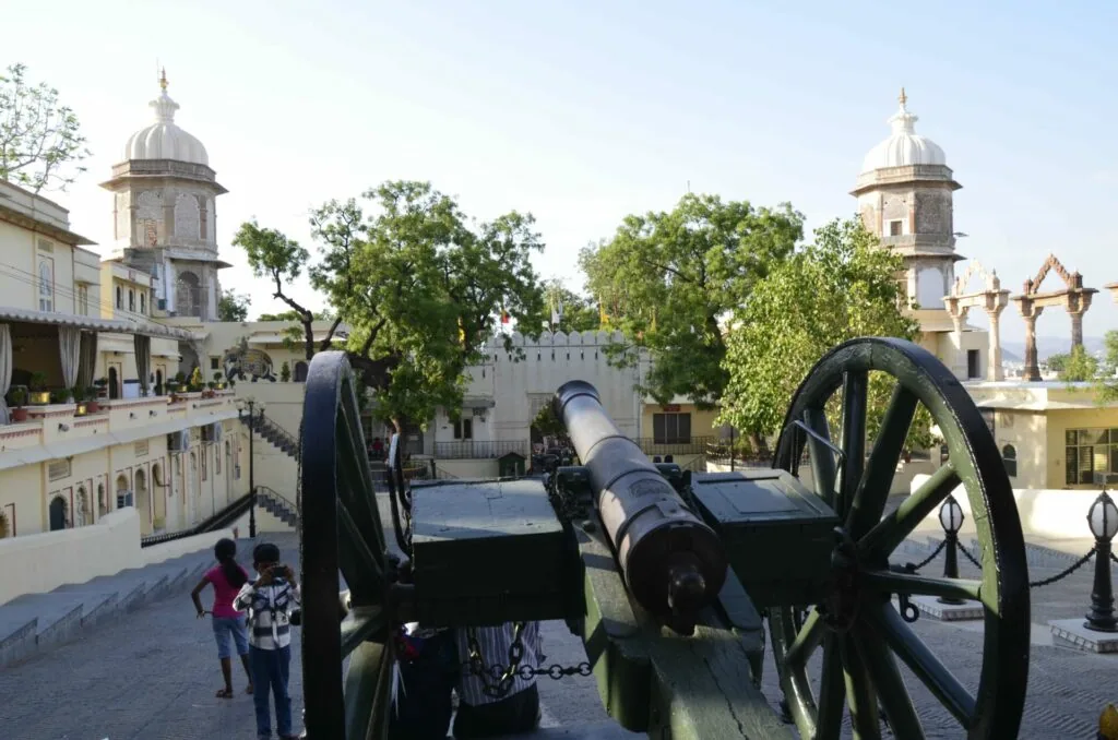Historic fortress courtyard with ornamental cannons, domed towers, and crenellated walls under clear sky