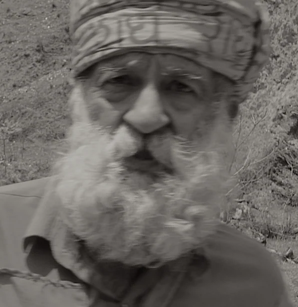 Elderly man with long white beard and headwrap in black and white portrait
