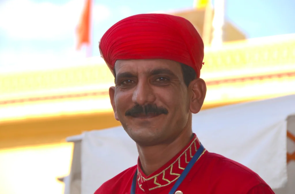Man wearing red turban and traditional red tunic with ornate embroidered neckline