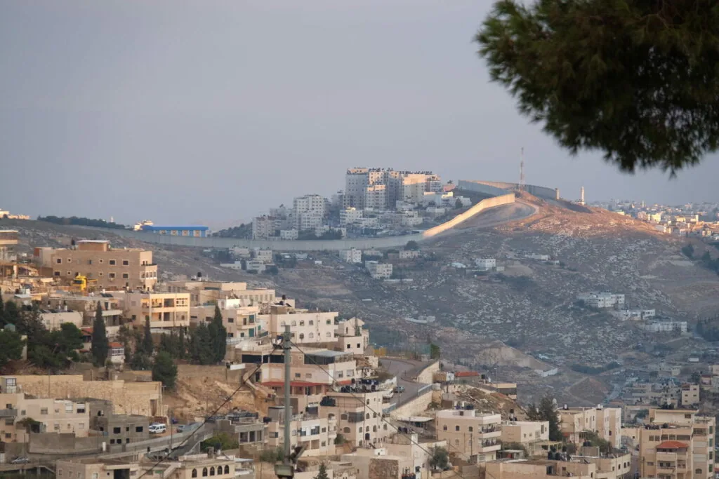 Hillside settlement with multi-story residential buildings built on terraced slopes under hazy sky