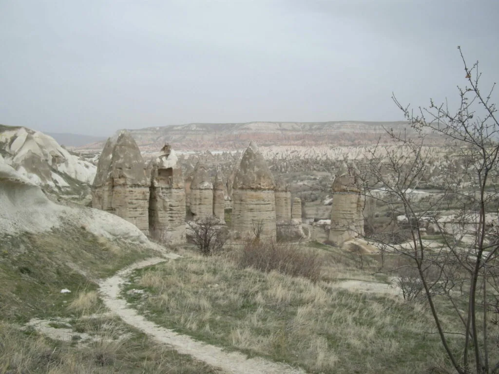 Fairy chimneys and rock formations in a semi-arid landscape with sparse vegetation and eroded terrain