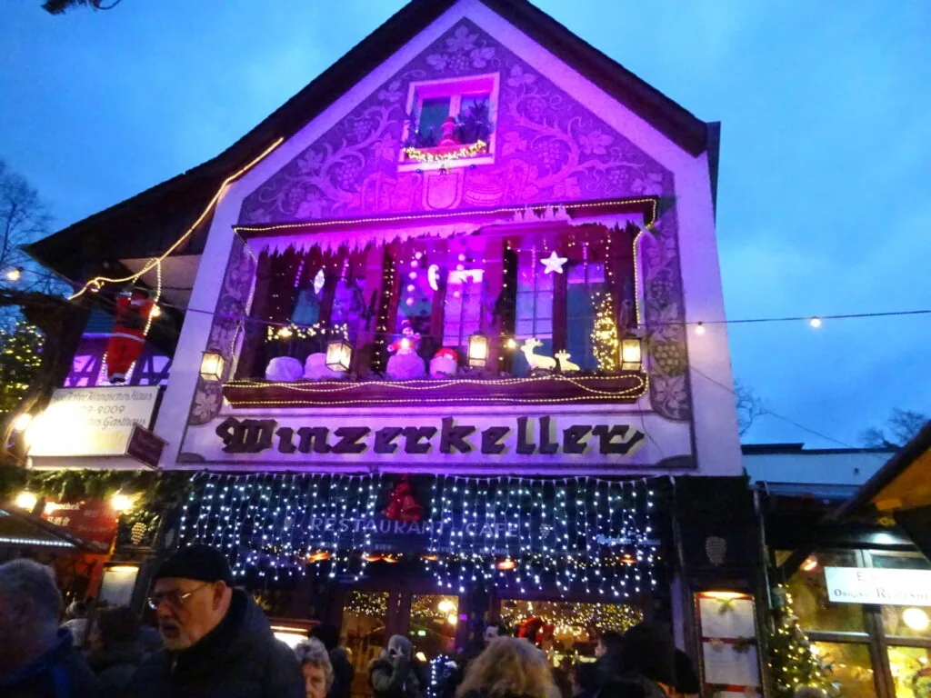 Illuminated white building with purple neon lighting and festive holiday decorations at dusk